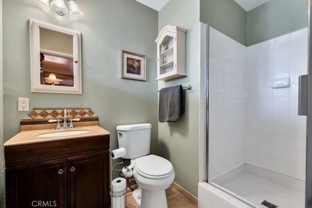 bathroom with vanity, tiled shower, tile patterned floors, and toilet