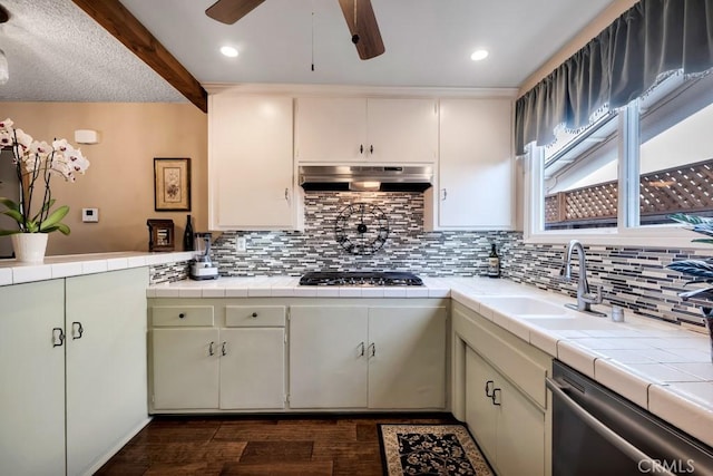 kitchen with dark wood-type flooring, sink, extractor fan, appliances with stainless steel finishes, and tile counters