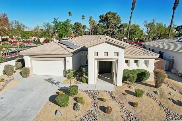 view of front facade featuring a garage and solar panels