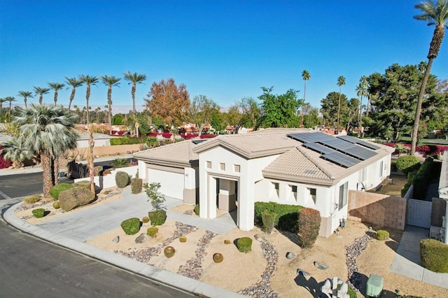 view of front of property with a garage and solar panels