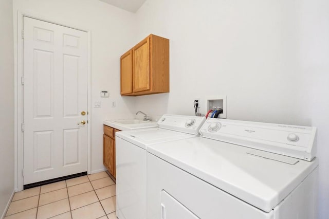 laundry area featuring separate washer and dryer, sink, cabinets, and light tile patterned flooring