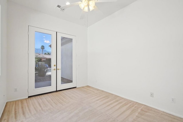 spare room featuring french doors, ceiling fan, and light carpet