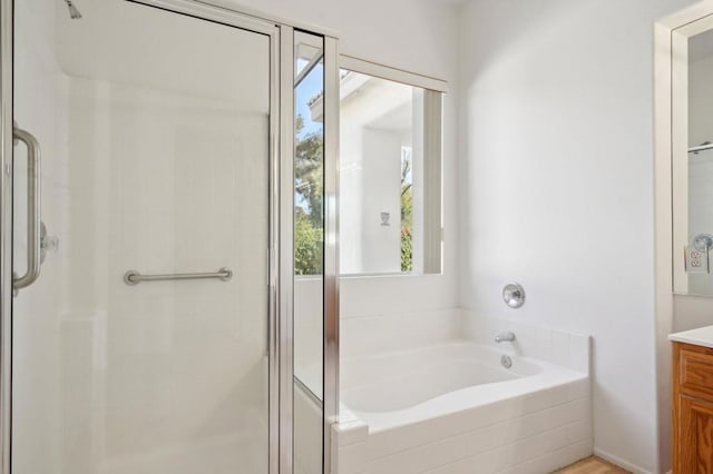 bathroom with vanity and shower with separate bathtub