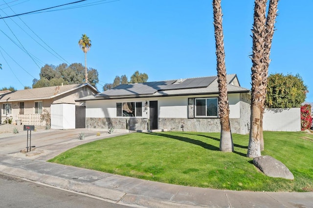 ranch-style house featuring a front yard and solar panels