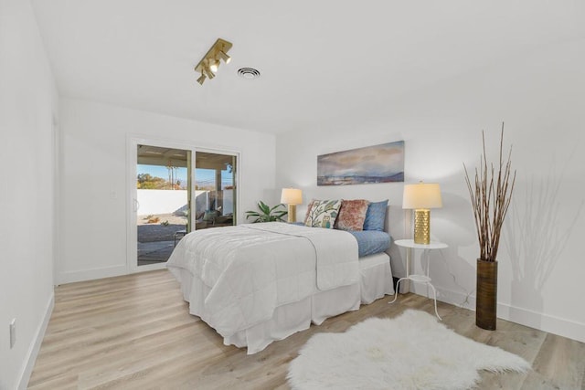 bedroom featuring access to exterior and light wood-type flooring