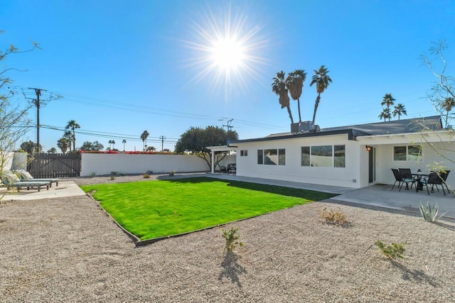 back of property with a yard and a patio area