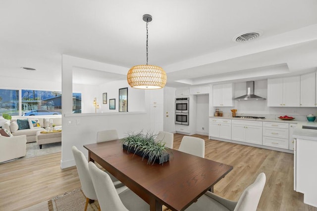 dining room with light hardwood / wood-style flooring and a wealth of natural light