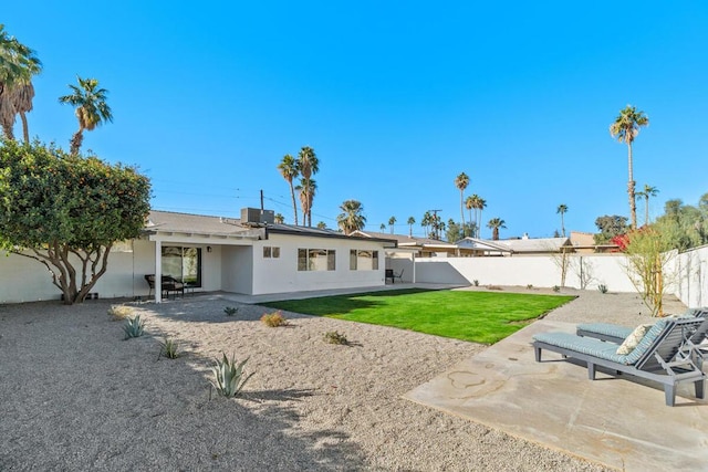 back of property with a patio, central air condition unit, and a lawn