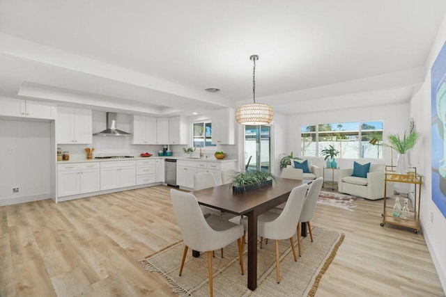 dining area with sink, a wealth of natural light, and light wood-type flooring