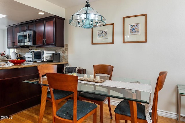 dining room featuring an inviting chandelier and light wood-type flooring