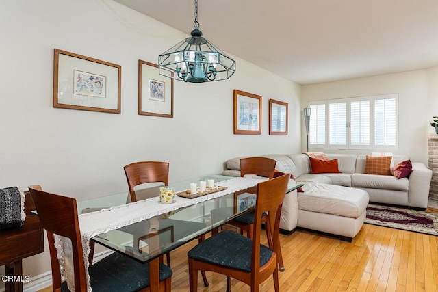 dining area featuring a notable chandelier and light wood-type flooring