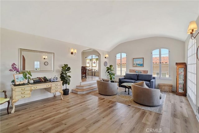 living room featuring light hardwood / wood-style flooring, vaulted ceiling, and brick ceiling