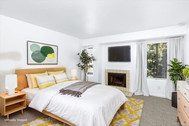 carpeted bedroom featuring a tiled fireplace