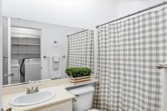 bathroom with toilet, washer / dryer, a shower with curtain, and vanity