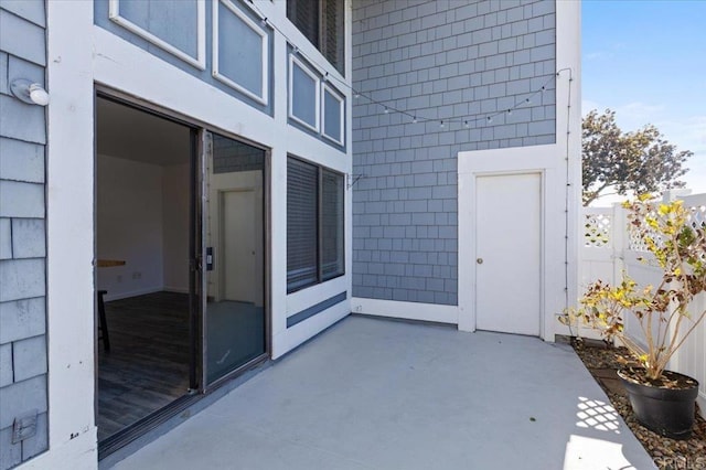 property entrance featuring a patio and fence