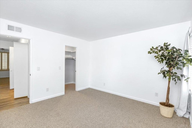 empty room featuring carpet, visible vents, and baseboards