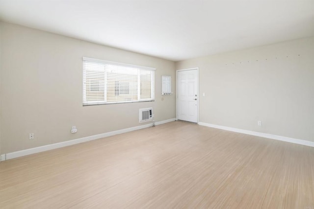 empty room with heating unit and light hardwood / wood-style floors