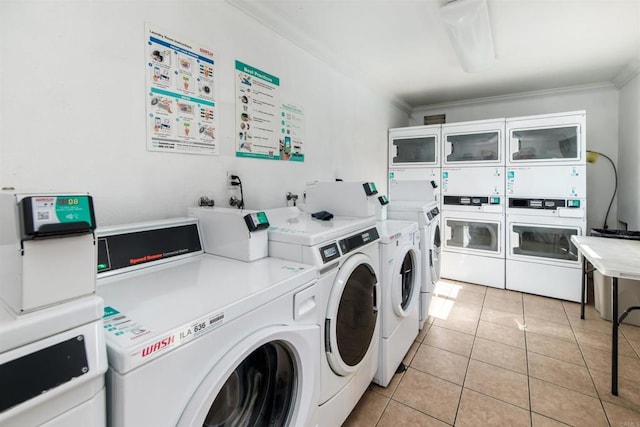 washroom featuring light tile patterned flooring, ornamental molding, stacked washer / drying machine, and washer and clothes dryer