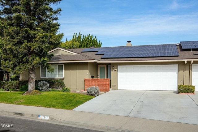 ranch-style home featuring a garage, a front yard, and solar panels