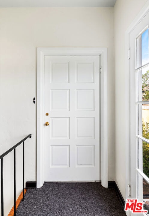 entryway with dark carpet