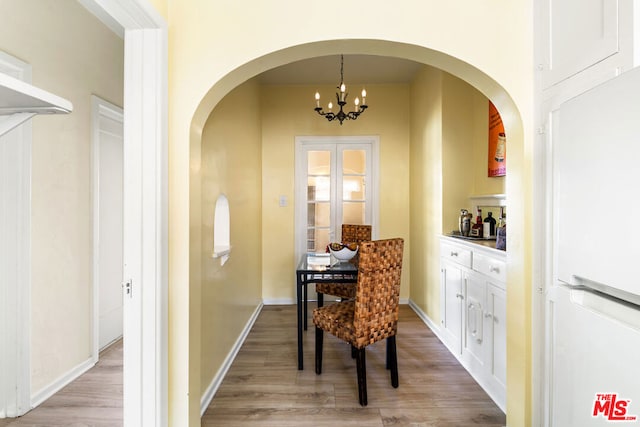 dining area featuring light hardwood / wood-style floors and a chandelier