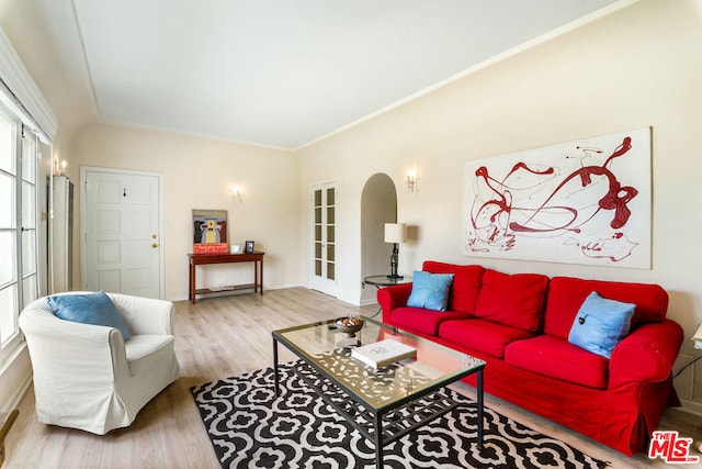 living room with french doors, ornamental molding, and light hardwood / wood-style flooring