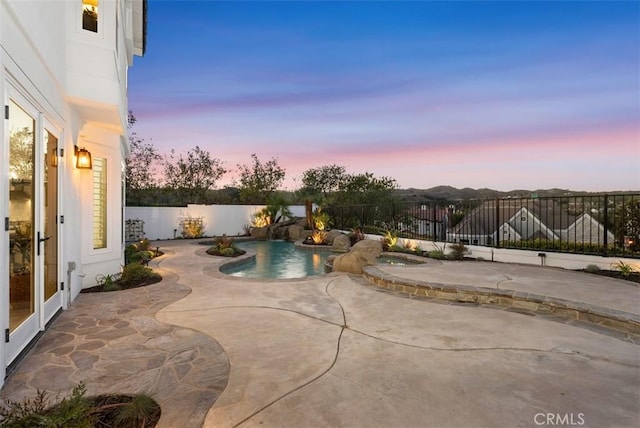 pool at dusk featuring a patio area