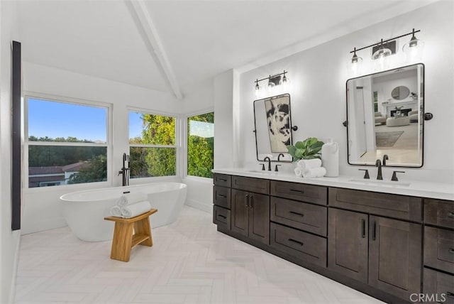 bathroom featuring vanity, a bath, and beamed ceiling