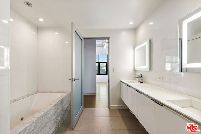 bathroom featuring vanity, a bathing tub, and tile patterned flooring