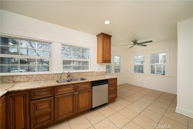 kitchen featuring brown cabinetry, dishwasher, a sink, and light tile patterned floors