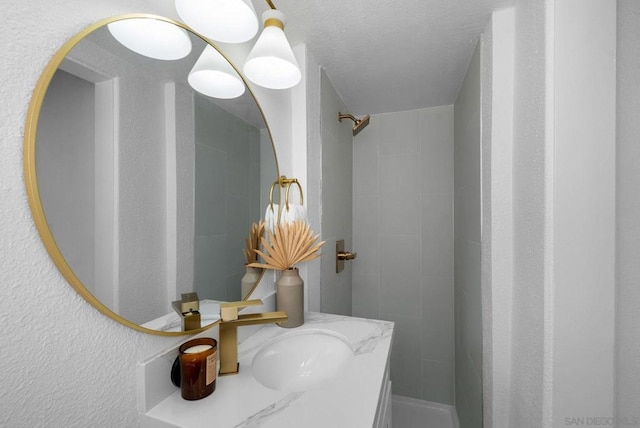 bathroom with vanity and a tile shower