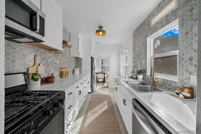 kitchen featuring sink, a wealth of natural light, stainless steel appliances, and white cabinets