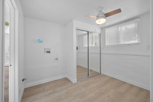 unfurnished bedroom featuring light hardwood / wood-style flooring, ceiling fan, and a closet