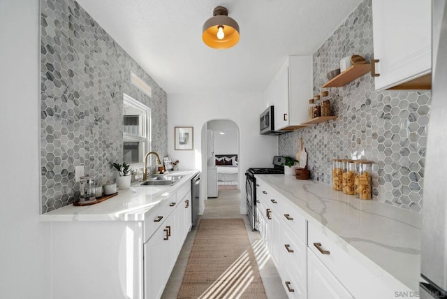 kitchen featuring white cabinetry, sink, backsplash, and appliances with stainless steel finishes