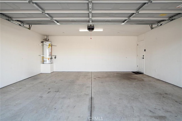 garage with strapped water heater and a garage door opener