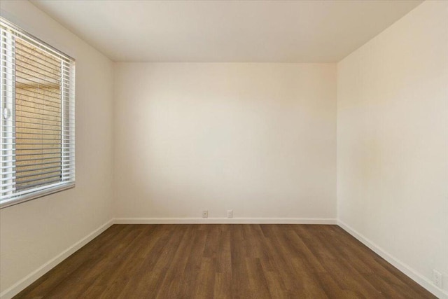 empty room with dark wood-type flooring and plenty of natural light