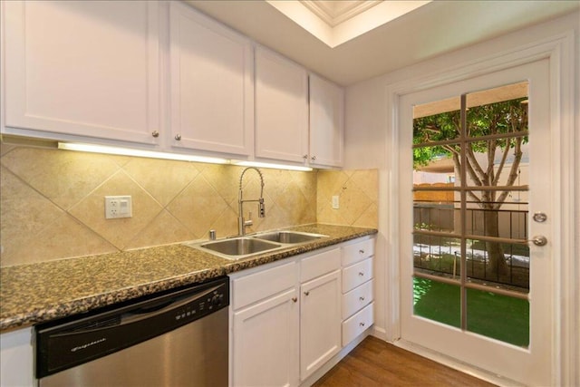 kitchen featuring dark stone counters, dishwasher, sink, and white cabinets