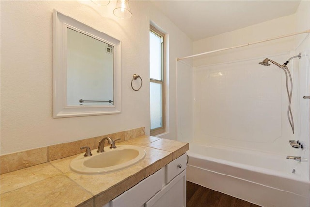 bathroom with vanity, hardwood / wood-style floors, and shower / bathing tub combination