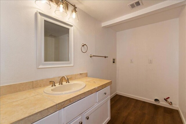 bathroom featuring vanity, hardwood / wood-style floors, and a textured ceiling