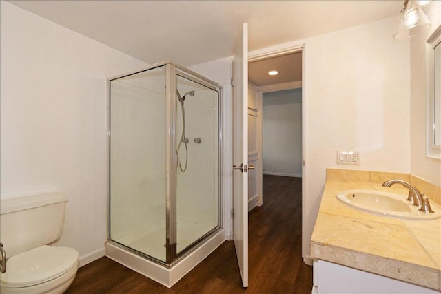 bathroom with a shower with door, vanity, wood-type flooring, and toilet