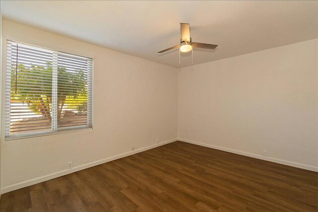 unfurnished room featuring ceiling fan and dark hardwood / wood-style flooring