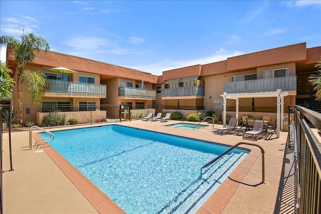 view of swimming pool featuring a patio area and a hot tub