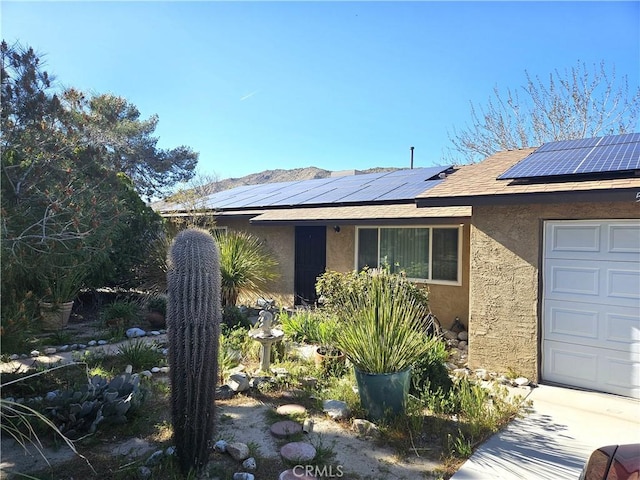 view of front of house featuring a garage and solar panels