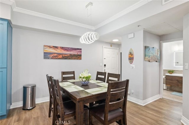 dining area featuring ornamental molding and light wood-type flooring