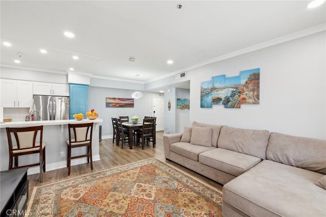 living room with crown molding and light hardwood / wood-style floors