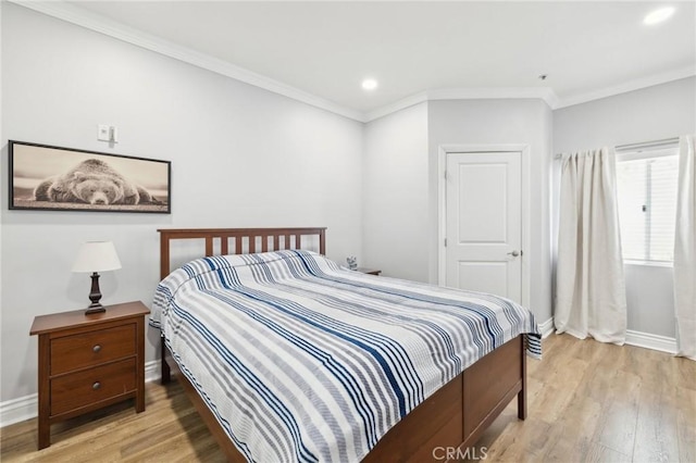 bedroom with ornamental molding and light hardwood / wood-style floors