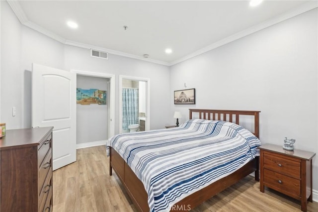 bedroom with crown molding, light wood-type flooring, and ensuite bath