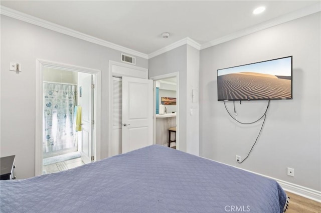 unfurnished bedroom featuring connected bathroom, hardwood / wood-style flooring, and ornamental molding