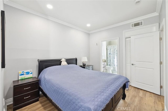 bedroom with crown molding, ensuite bath, and light wood-type flooring