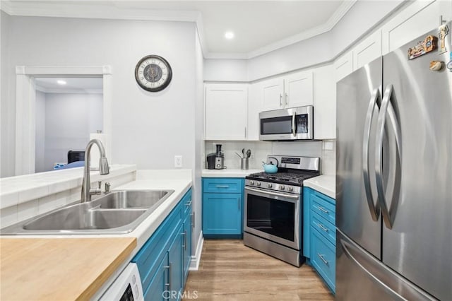 kitchen with blue cabinetry, appliances with stainless steel finishes, sink, and white cabinets